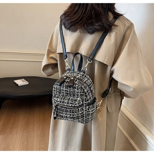 Dettaglio dell'elegante trama in tweed bianco e nero di una borsa a tracolla da donna