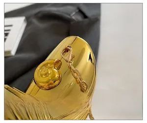 Detail der hochglanzpolierten goldenen Abendtasche mit Schneckenverschluss und Kette