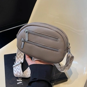 Minimalist taupe pebble leather round crossbody bag with stylish geometric wide strap