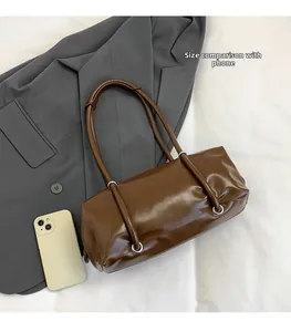 Detail view of coffee brown PU Boston bag with smartphone for size comparison