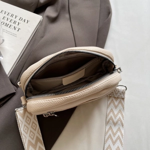 Chic beige lychee leather crossbody circle bag with wide jacquard shoulder strap for daily use