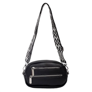 Black pebbled leather crossbody round bag with geometric wide strap and dual zippers