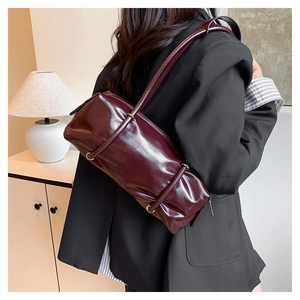 Detail of dark red PU leather Boston bag showing fine texture and sleek shoulder strap