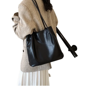 Chic black pleated shoulder bag for women styled with casual office blazer and skirt
