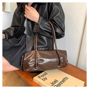 Detail of dark brown leather Boston bag showing smooth texture and unique strap eyelets