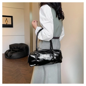 Modern black oil wax PU Boston bag styled by a model in a minimalist home setting