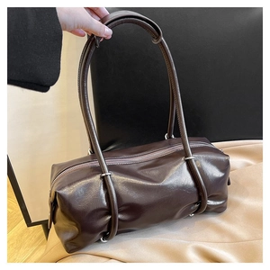 Macro view of dark brown PU leather Boston bag with natural texture and thin shoulder straps