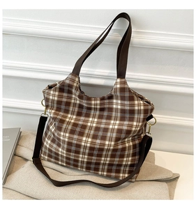 Detail of brown plaid tote bag with thick canvas texture and sturdy gold metal rings