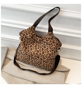 Macro shot of leopard print canvas tote with brown straps and gold metal hardware rings
