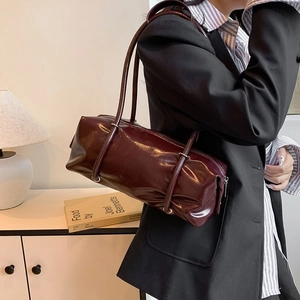 Burgundy PU leather Boston bag shown on model with dual straps for shoulder or crossbody