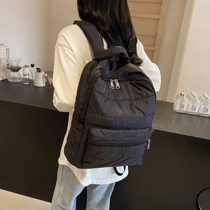 Chic black quilted nylon backpack with silver zippers and padded straps for women