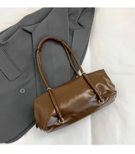 Detail of a glossy brown PU leather Boston bag with double handles for commuting