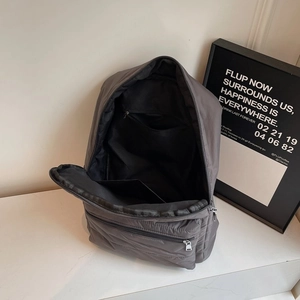 Quilted puffer backpack in dark grey nylon with interior zip pocket for daily use
