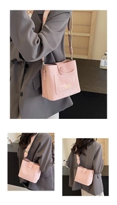 Detail of pink bucket bag with wide jacquard strap and stitched fashion pockets