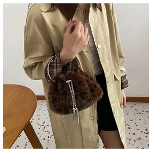 Detail of faux fur leopard print bucket bag with silver metal handle and chain strap