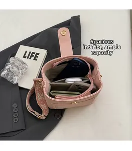 Detail view of pink bucket bag interior with organized compartments and ethnic wide strap