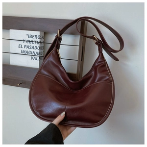 Close-up of wine red hobo bag featuring premium stitching and adjustable gold buckle