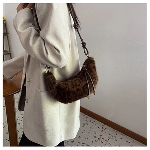 Detail of faux fur crescent bag with knotted leather strap and gold-tone hardware