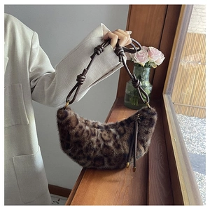 Detailed view of leopard print plush hobo bag with knotted faux leather strap on windowsill
