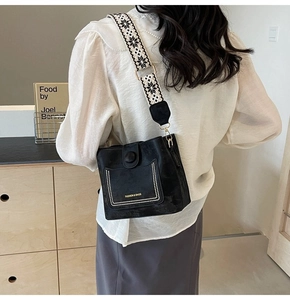 Detail of vintage black bucket bag with ethnic geometric woven wide shoulder strap