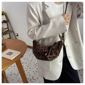Detail shot of leopard print plush crescent bag with metal ball zipper on beige blazer