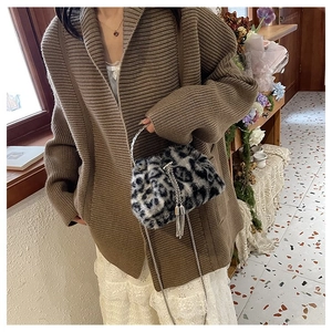 Detail of leopard print faux fur bucket bag with silver chain strap and tassel charm