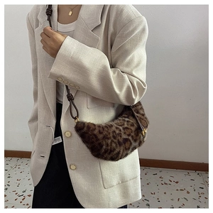 Close-up of leopard print faux fur crossbody bag with crescent moon shape and metal clasp
