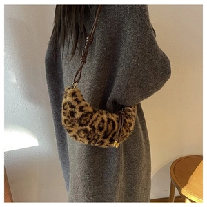 Macro detail of plush leopard print faux fur and knotted strap on crescent bag