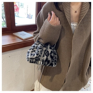 Detail of leopard print faux fur bucket bag with silver metal tassels and chain strap