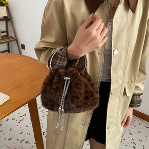 Chic leopard print faux fur bucket bag with silver handles and elegant chain tassel detail