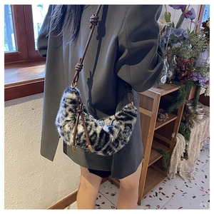 Detail of leopard print crescent bag with textured faux fur and braided rope strap