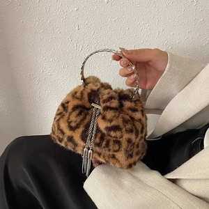 Close-up of winter leopard bucket bag with silver ring handle and tassel chain