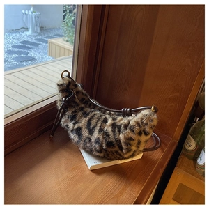Detail of leopard print faux fur crescent bag with leather knot shoulder strap design