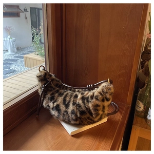 Detailed view of leopard faux fur crescent bag on window sill with stylish stitching