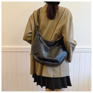 Minimalist black leather crescent hobo bag with adjustable strap in street style