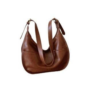 Brown leather half-moon hobo bag with vertical stitching and golden buckle strap