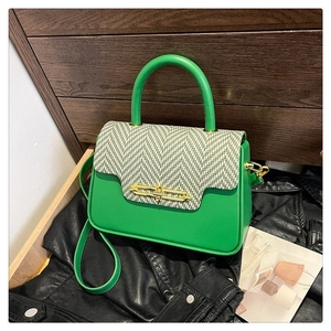 Detail of green PU leather handbag with tweed flap and golden clasp closure