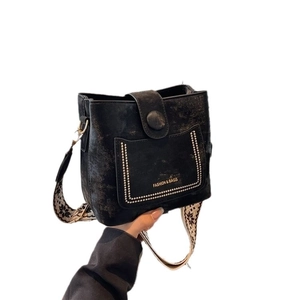 Retro black bucket bag with embroidered wide shoulder strap and studded pocket detail