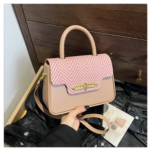 Detail of elegant crossbody bag with red herringbone flap and gold metal latch
