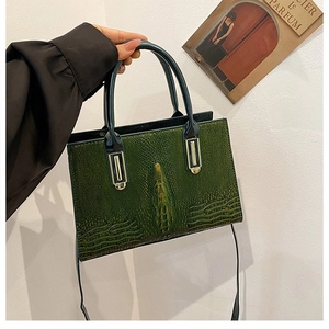 Detailansicht der dunkelgrünen Krokodiltextur und Wirbelsäulenrelief der Handtasche