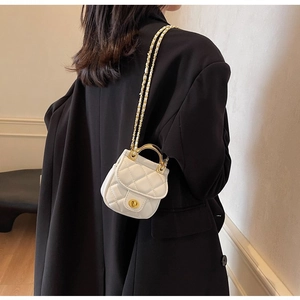 Vue détaillée d'un mini sac matelassé blanc avec chaîne dorée porté par un mannequin