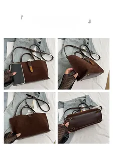 Detail view of brown matte handbag showing stitching, metal feet, and adjustable strap