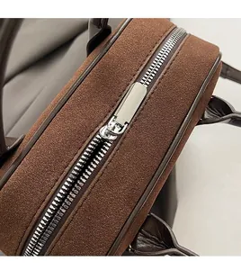 Détail de la fermeture éclair métallique lisse sur le sac à main vintage en daim marron