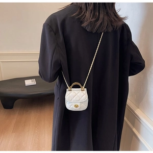 Détail du mini sac blanc matelassé avec poignée en métal doré et bandoulière chaîne