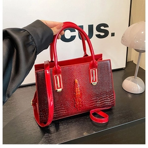 Details der roten Krokodil-Handtasche mit 3D-Krokodil-Anhänger und goldenen Metallelementen