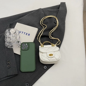 Détail du sac matelassé blanc avec chaîne dorée et poignée en métal sur blazer gris
