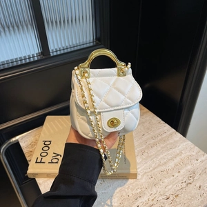Détail du mini sac blanc matelassé avec poignée dorée et fermoir pivotant chic
