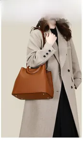 Close-up of brown PU leather tote bag featuring woven handles and lychee texture grain
