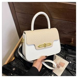 Two-tone beige crossbody Kelly bag with woven flap and golden lock on dark background