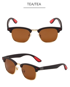 Dettaglio di occhiali da sole semi-rimless con lenti color tè, accenti oro e punte rosse